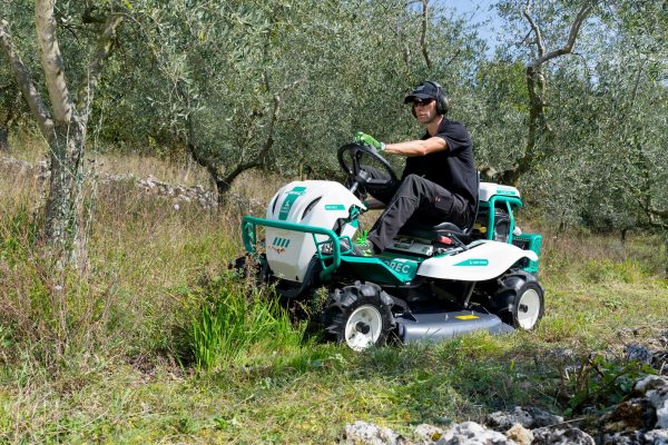 photo autoportée debrousailleuse verte orec en pleine action entre des arbres